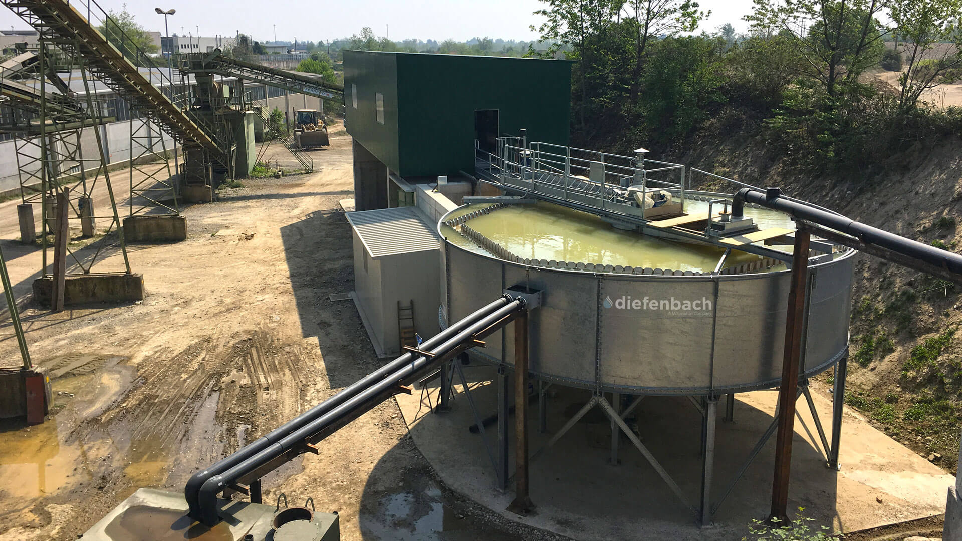 An elevated high-rate thickener full of liquid operating on site