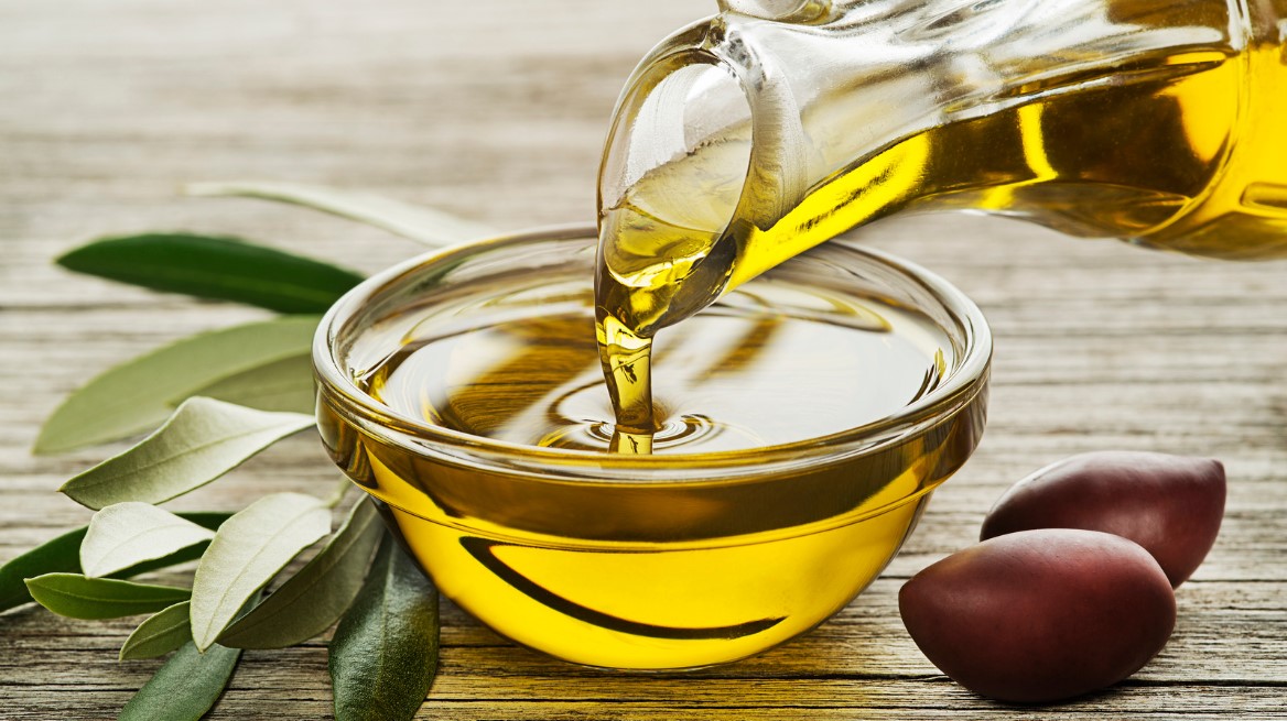 Nahaufnahme von Olivenöl, das in eine Glasschale gegossen wird