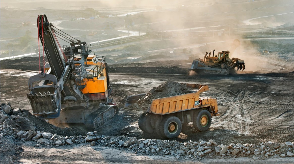 Camiones y excavadoras de minería a cielo abierto moviendo escombros